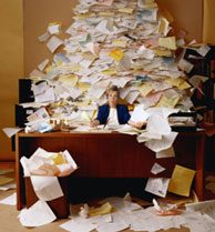 Woman under large stack of papers